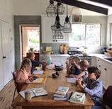 Children working on homeschool lessons at the kitchen table