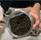 a person holding a jar of lemon balm herb