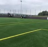 a man is playing tennis on a green field