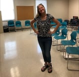 an educator standing in a classroom with a blackboard