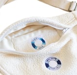 Détail du sac sacoche ÉTOFÉ en tissu recyclé blanc, avec étiquette personnalisée Hôtel du Cap-Eden