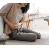 a woman sitting on a couch with her stomach
