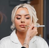 a blonde women having her bridal makeup done