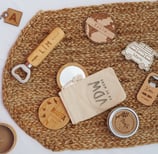 a table with a bag of personalized wood items and a bottle opener