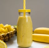 a glass jar of lemonade with a strawberries and lemonade