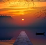 Coucher de soleil sur un lac avec une barque et une avancée en bois