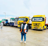 a man standing in front of a group of trucks