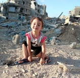 a young girl sitting on a pile of rubble