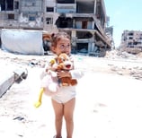 a young girl holding a stuffed animal toy