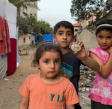 three young children standing in a dirt road