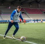 Joueur de foot à l'échauffement sur le point de faire un centre