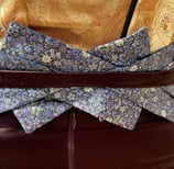 The blue floral belt of a gold brocade and brown satin evening gown