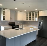 Two-tone RTA kitchen in Kelowna, navy base cabinets, white shaker uppers and a quartz island sinksin