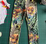 a pair of leggings with a peacock print