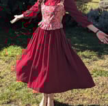 Aude Fy en robe rouge et corset folklorique