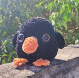 a stuffed penguin sitting on a ledge
