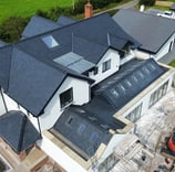 a house with a large roof and a large house with a black roof