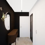 Vue d'un couloir avec un mur noir, un miroir rond et une applique murale après projet