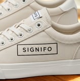 Desain sepatu sneakers kanvas mocha SIGNIFO dengan logo di bagian samping.