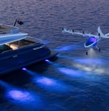 a plane flying over a boat in the ocean