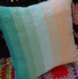a tunisian crochet pillow with a colorful blanket