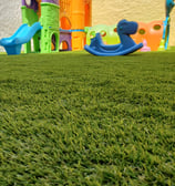 pasto sintetico instalado en una terraza infantil con juegos