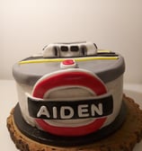 a cake with a train themed cake on top of a wooden slice