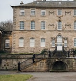 a large stone building with a staircase leading with bride and groom