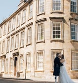 a bride and groom standing in front of a building