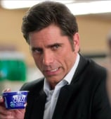 John Stamos holds an Oikos while talking to a cashier