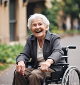 An elderly person with white hair sits in a wheelchair facing away from the camera. They are positioned near a worn doorway with textured walls and a brick interior visible beyond. A sign in an East Asian script is attached to the door nearby.