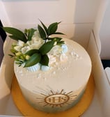 a cake with white flowers in a box