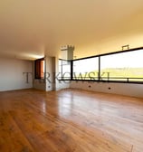 piso de departamento con suelo de madera murallas color blanco, ventanas amplias y bien iluminado