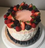 a cake with berries and berries on a white plate