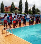 a group of people standing around a pool