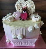 a cake with a teddy bear on top of a pink cake