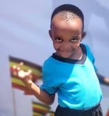 a young boy with a blue shirt and black shorts