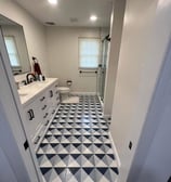 a bathroom with a black and white tiled floor