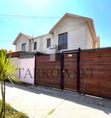 casa blanca de dos pisos con cuatro ventanas y portón café con palmera al frente a la venta