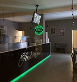 Bancone interno di AndrèsRosa Pizzeria ad Alseno con il logo visibile, ambiente accogliente e modern