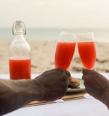 cheers two glasses clinking private beach dinner Barbados 