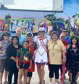 a group of people standing in front of a mural