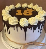 a cake with white frosting and chocolate icing