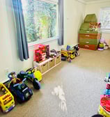 an organized playroom with a window and toys