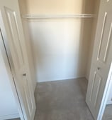 an empty closet with a closet door open and a closet with a shelf