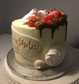 a cake with a chocolate cake and strawberries on top