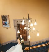 a bride and groom standing on a staircase way