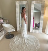 a woman in a wedding dress standing in front of a mirror