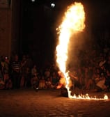 momento dello spettacolo di fuoco firestorm con la frusta infuocata e l'arte dello sputafuoco