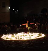 artista di strada durante il numero della colata di fuoco immerso nelle fiamme sul pavimento